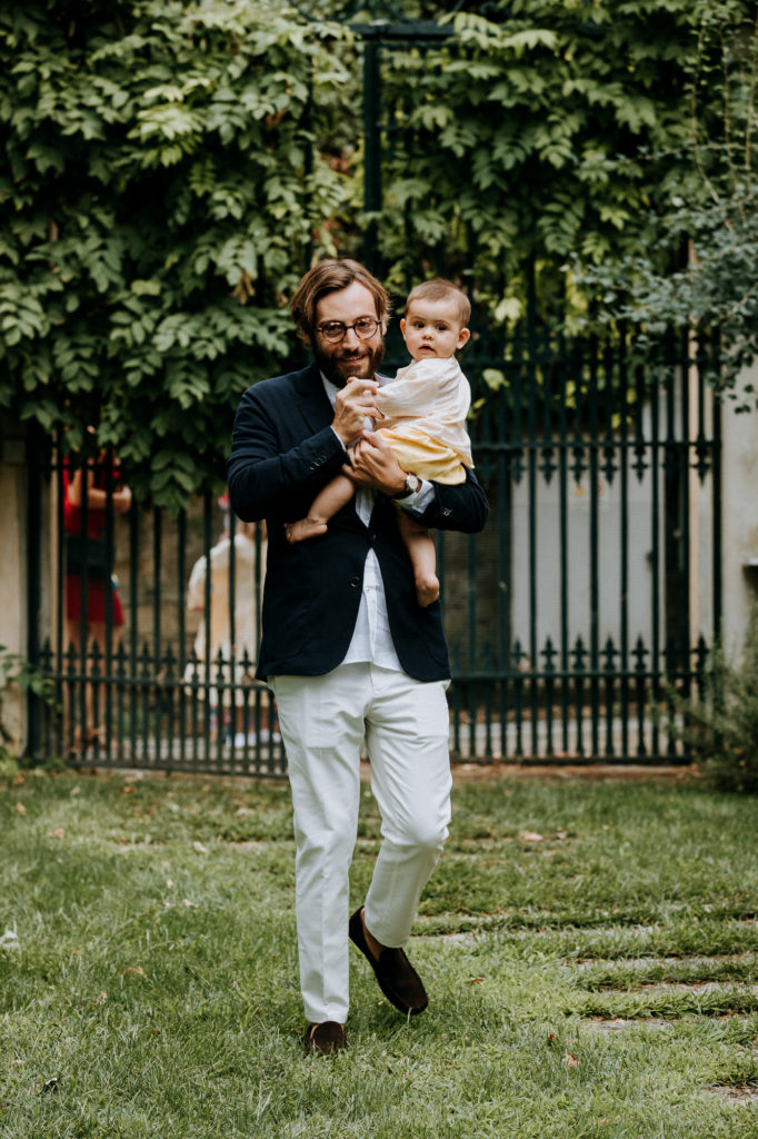 the groom walks down the aisle, his son in his arms