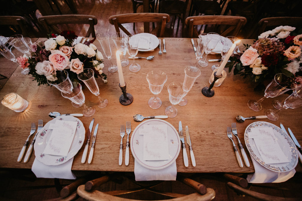 La jolie décoration pour le diner, avec des tables en bois brut