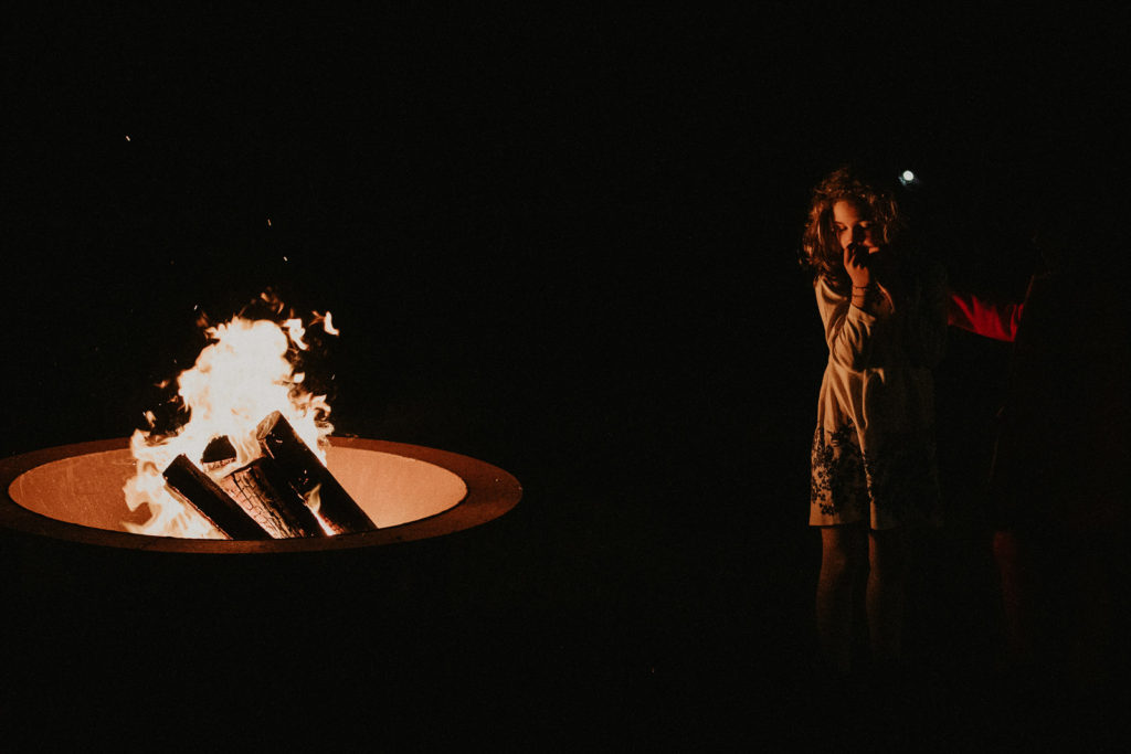 Une petite fille se rechauffe auprès du feu