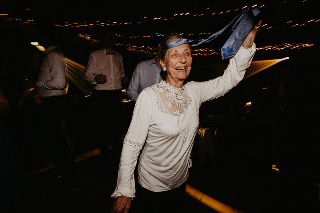 Une grande mère de 84 ans danse sur la piste, une cravate autour du front